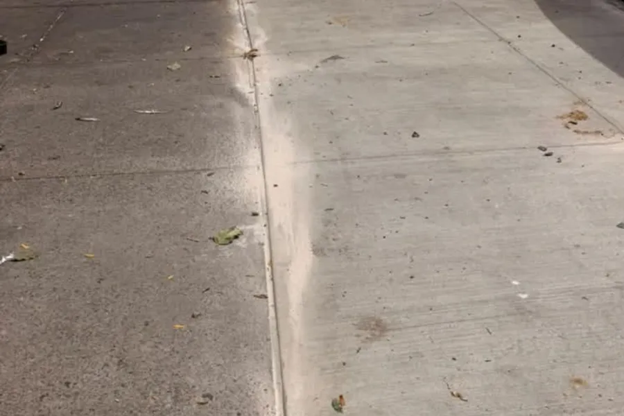 Newly replaced sidewalk slabs at a mixed-use property on Utica Ave in Crown Heights, Brooklyn after NYC DOT violation repairs.