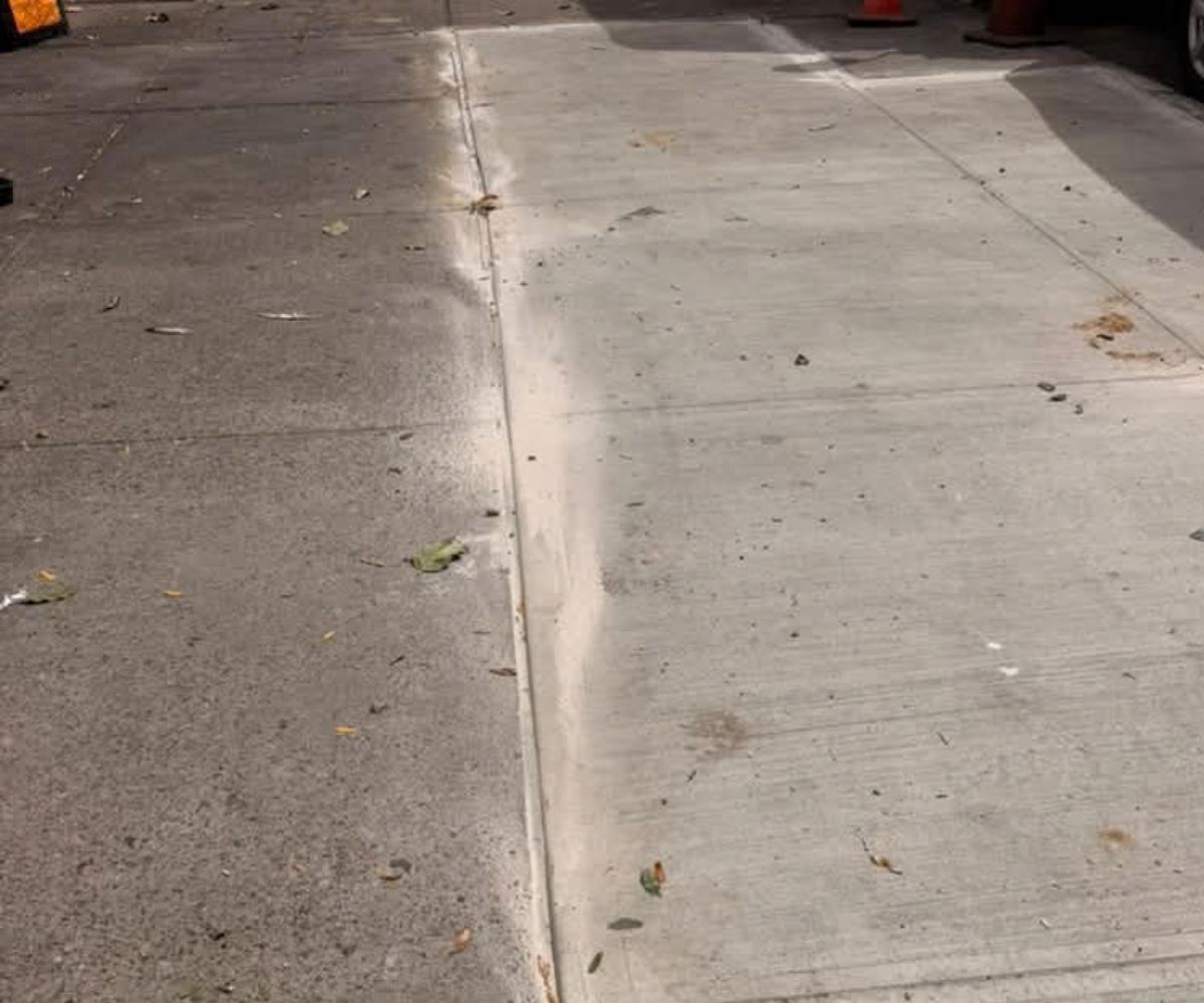Newly replaced sidewalk slabs at a mixed-use property on Utica Ave in Crown Heights, Brooklyn after NYC DOT violation repairs.