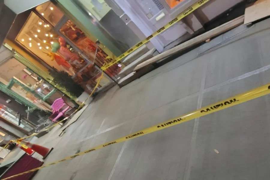 Newly replaced concrete sidewalk slabs behind caution tape outside Baya Bar at 232 Mulberry Street, Nolita.
