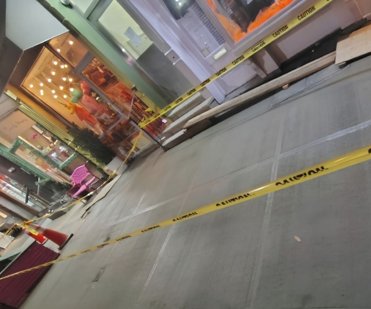Newly replaced concrete sidewalk slabs behind caution tape outside Baya Bar at 232 Mulberry Street, Nolita.