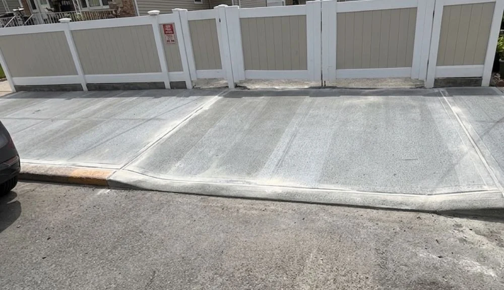 finished sidewalk and curb cut replacement with smooth concrete in front of a queens residential property