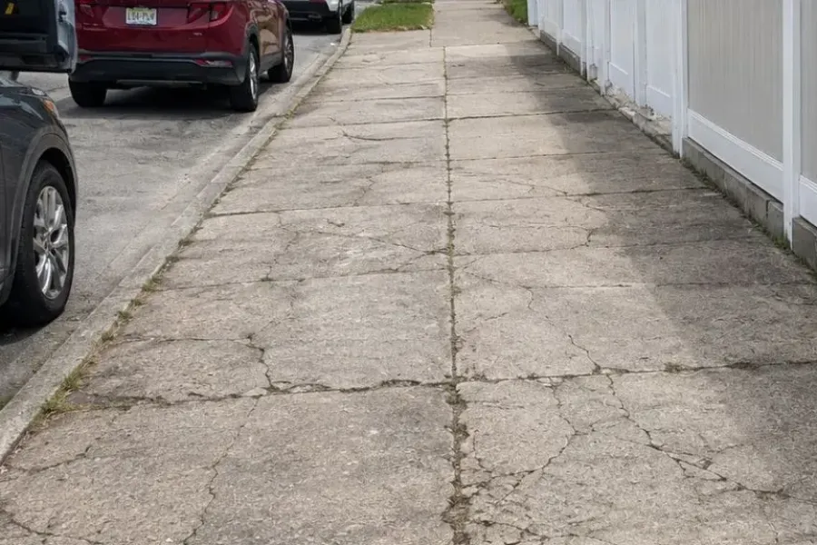 Cracked and settled sidewalk slabs before repair in Queens, New York