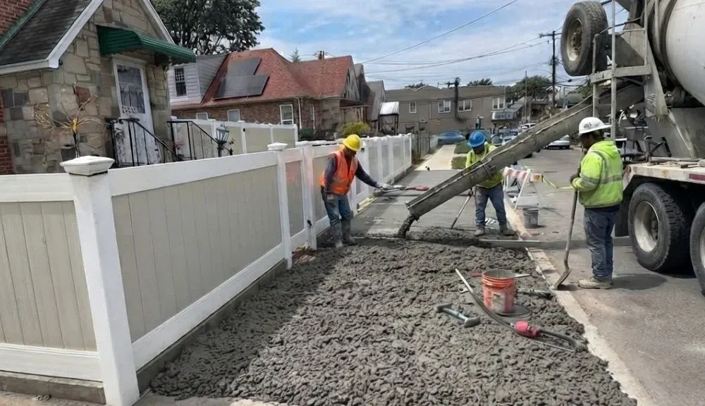Fresh concrete being poured during a Queens sidewalk repair